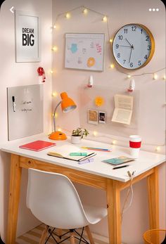 a white desk topped with a laptop computer next to a clock