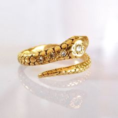 Beautifully detailed carved 18k solid gold snake ring with glistening diamonds. Snake Totem is powerfully connected to life force and primal energy. In many cultures, it is revered as a powerful totem representing the source of life and ultimate spiritual guide animal. Embrace transformation and Re-birth. Made with Love at our Temple jewels studio in Ibiza. Materials: 18k solid yellow gold Diamond SI Quality Ethically sourced and Guaranteed by A.A. Rachminov Diamonds Can be custom made in White Luxury Yellow Gold Unique Snake Ring, Luxury Gold Diamond Snake Ring, Luxury Fine Jewelry Yellow Gold Snake Ring, Luxury Hallmarked Gold Snake Ring, Snake Totem, Gold Snake Ring With 17 Jewels, Fine Jewelry, Snake Ring Gold, Rings Jewelry Simple, Symbol Of Power