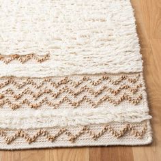 a close up of a rug on a wooden floor with wood floors and white carpet