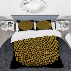 a bed with yellow and black designs on the comforter, pillows and pillow cases