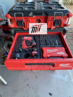 a red tool box filled with tools sitting on top of a table