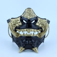 a gold and black mask with horns on it