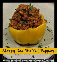 a white plate topped with a stuffed yellow pepper covered in ground beef and herbs on top of it