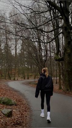 a woman walking down a path in the woods