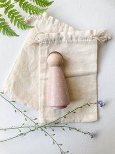 a small pink object sitting on top of a white bag next to a green plant