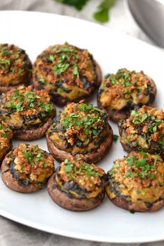 a white plate topped with mini mushrooms covered in toppings