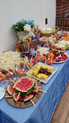 a blue table topped with watermelon slices and other foods on top of it