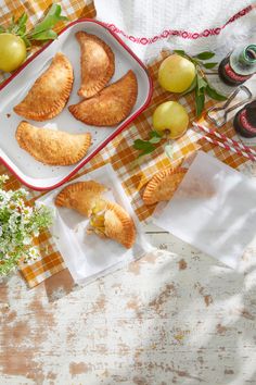 several pastries on a table with flowers and fruit