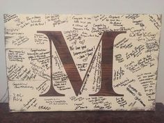 a wooden block with the letter m covered in many different handwritten letters and numbers