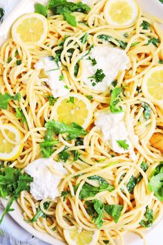 a plate of pasta with lemons, parmesan cheese and cilantro