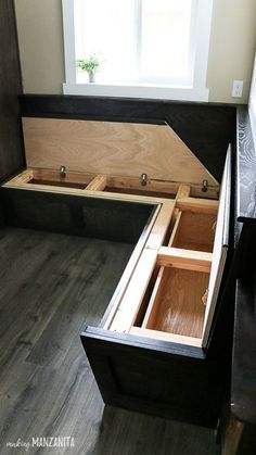 an open chest sitting on top of a wooden floor next to a window in a room