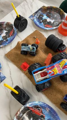 a table topped with plates covered in monster trucks