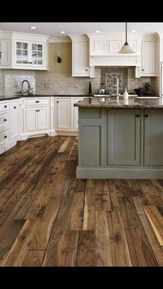 a kitchen with wooden floors and white cabinets