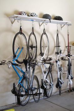 several bicycles are hanging on the wall in front of a bicycle rack with helmet racks