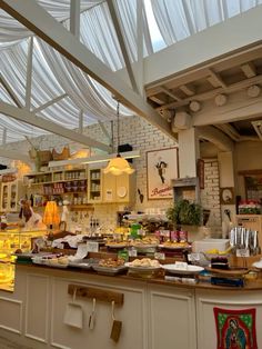 a kitchen filled with lots of food under a glass ceiling covered in white plastic covering