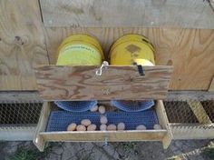 two buckets and some eggs in a wooden crate