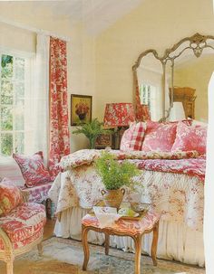 a bed room with a neatly made bed next to a chair and table in front of a window