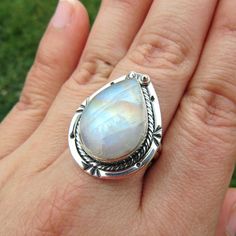 SKU: SS-061Material: 925 stamped sterling silverGemstone(s): Rainbow Moonstone (N)Gemstone Dimensions: 13 X 19 X 4 mmRing Size: US 8Weight: 8.1 gramsThis eye-catching Rainbow Moonstone ring features a teardrop Rainbow Moonstone cabochon, set in a classic bezel with a modern braid border that accents the stone beautifully. This Rainbow Moonstone lives up to its name, showcasing blue, orange and yellow fire all throughout the stone. Fine Jewelry Pear-shaped Moonstone Ring, Fine Jewelry Moonstone Teardrop Ring, Fine Jewelry Teardrop Moonstone Ring, Pear-shaped Moonstone Gemstone Ring, Untreated Teardrop Silver Ring, Silver Teardrop Natural Gemstones, Silver Teardrop Cabochon Rings, Teardrop Moonstone Gemstone Ring, Teardrop Silver Gemstones For Jewelry Making