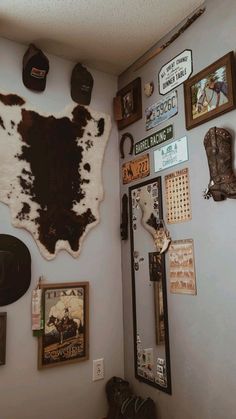 the wall is covered with various framed pictures and cowhide rugs on it's sides