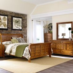 a bedroom scene with focus on the bed, dresser and mirror in the room's center