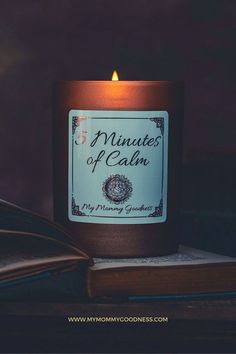 a candle with the words minutes of calm on it sitting next to an open book