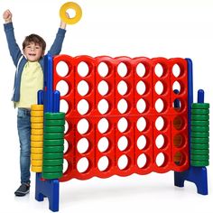 a little boy standing next to a giant board game with lots of circles on it