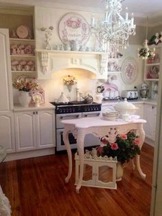 an old fashioned kitchen with white cabinets and pink flowers