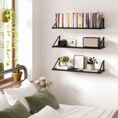 three shelves on the wall above a bed filled with books and other items in front of a window