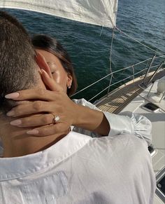 a man and woman embracing on the back of a boat