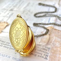 This is a romantic long pendant locket necklace. This golden brass locket folds out to reveal space for four different photos. The locket measures 30mm long by 22mm wide and hangs from an antique style chain or a golden brass chain. This lovely locket necklace makes a wonderful gift for mom! You can personalize your necklace with initial charms - https://www.etsy.com/listing/264281600/custom-initial-charm-brass-hand-stamped?ref=shop_home_active_1 Your locket necklace will arrive in a beige cotto Gold Brass Locket Necklace For Wedding, Gold Locket Necklace For Wedding, Gold Necklace With Antique Finish For Keepsake, Brass Locket Necklace Pendant For Wedding, Bronze Brass Locket Necklace For Wedding, Brass Pendant Locket Necklace For Wedding, Wedding Brass Locket Necklace With Pendant, Bronze Locket Necklace For Wedding, Gold Antique Finish Locket Necklace For Keepsake