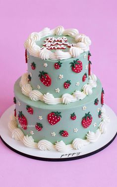 a three tiered cake with strawberries on it