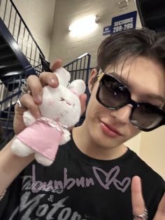 a person with sunglasses holding a stuffed animal