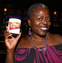 a woman holding up a jar of nutella in her right hand and smiling at the camera