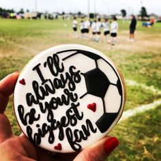 a person holding up a decorated cookie that says i'm always going to play soccer