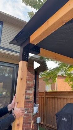 a man standing next to a house with an awning