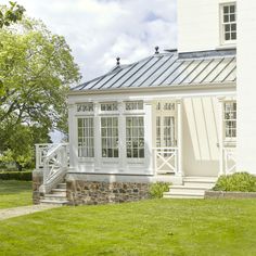 a white house sitting on top of a lush green field