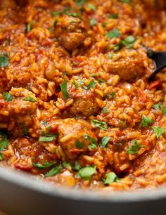 meatballs and rice in a pot with a spoon