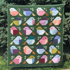 a green quilt with colorful birds on it