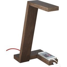 an electronic device is plugged in to a wooden table lamp that looks like the letter t