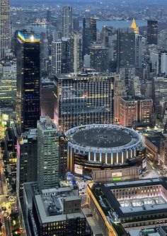 an aerial view of a city at night with tall buildings and skyscrapers in the background