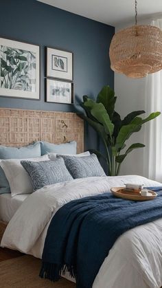 a bedroom with blue walls and white bedding, wicker headboard, rattan hanging lamp