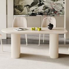 a white table with two chairs in front of it and a painting on the wall