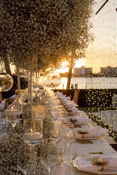 a long table is set with place settings for dinner guests to enjoy the view at sunset