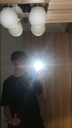 a man taking a selfie in front of a mirror with his camera light on