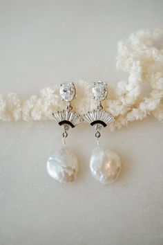 Our BELLE Freshwater Pearl Earrings are so unique and drop dead gorgeous. Made with white cubic zirconia and freshwater pearl, they're made to stand out. They were designed for the classic, yet bohemian chic bride. They add a beautiful touch to every bridal look!---------------------FEATURES◊ White cubic zirconia oval post (.925 sterling post, rhodium or gold plated)◊ Flat freshwater pearl ◊ Cubic zirconia fan pendant (rhodium/gold plated)◊ 100% nickel free, great for sensitive ears--> Get th Timeless Dangle Bridal Earrings For Wedding, White Gold Art Deco Wedding Earrings, Art Deco White Gold Wedding Earrings, Timeless Teardrop Bridal Earrings For Wedding, Timeless Teardrop Wedding Earrings, Timeless Drop Earrings For Bridal, Timeless Drop Bridal Earrings For Wedding, Timeless Cubic Zirconia Wedding Earrings, Timeless Wedding Drop Earrings