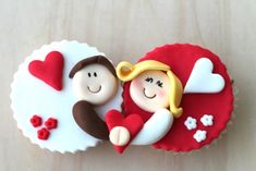 two cupcakes shaped like people laying next to each other