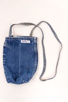 an old pair of blue jean shorts is hanging on a white wall with a cord