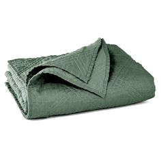 the green blanket is folded on top of each other