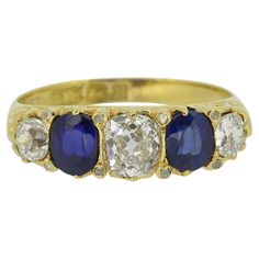 Here we have a classically styled five-stone ring taken from the Victorian era. This antique piece has been crafted from a rich 18ct yellow gold and showcases a single old cushion cut diamond at the centre of the face. This proud principal stone is then flanked on either side by excellently matched oval faceted sapphires possessing a vivid navy blue colour tone with an additional, slightly smaller, old cut diamond terminating the ensemble at each end. The piece is made complete by neatly nestled Classic Multi-stone Sapphire Ring, Victorian Diamond Ring, Garnet And Diamond Ring, Vintage Sapphire, Victorian Rings, Cushion Cut Diamonds, Edwardian Fashion, La Face, Sapphire Stone