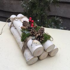 some logs are wrapped in twine with pine cones and berries